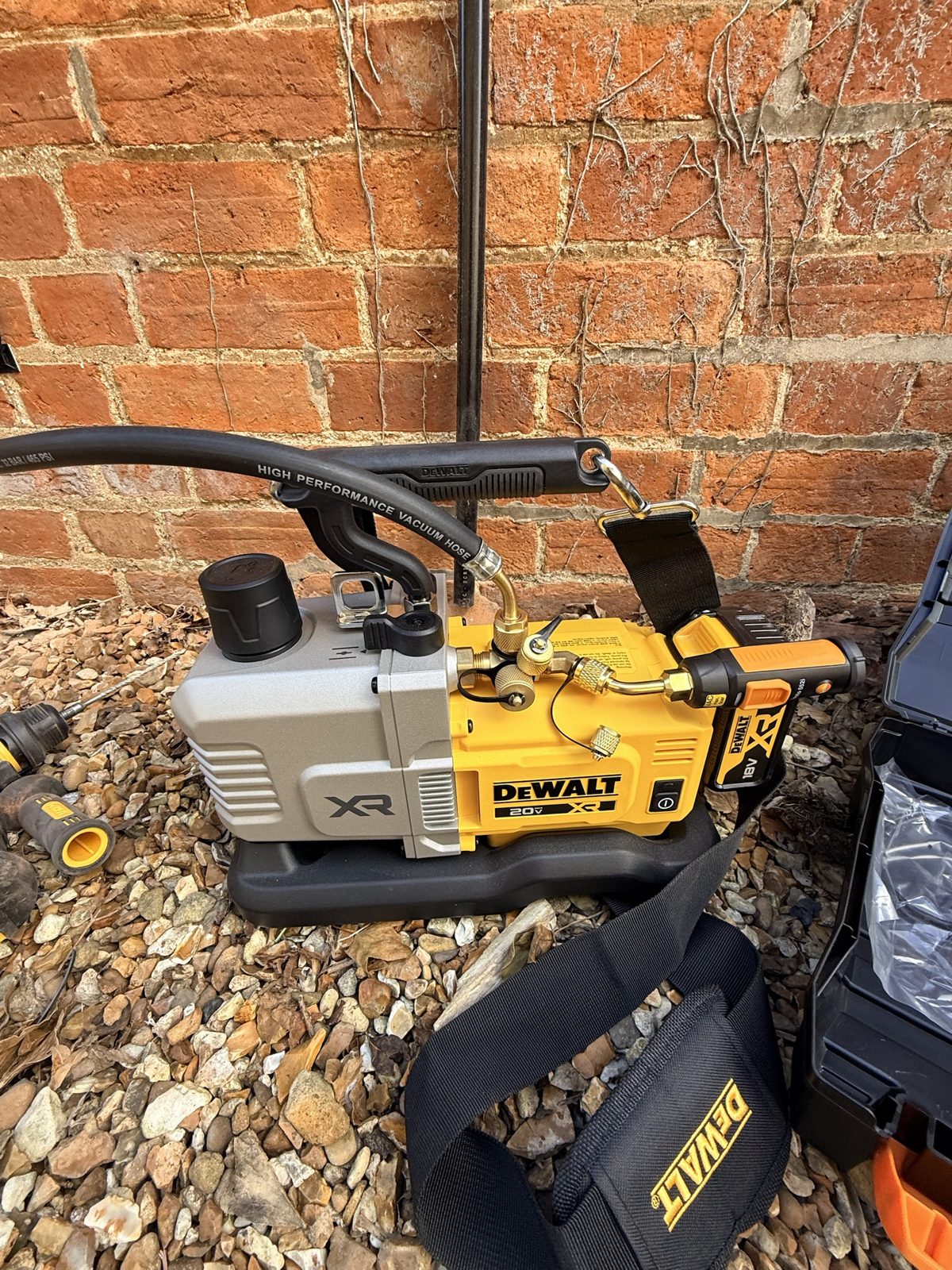 Cordless vacuum pump connected to the system beside the outdoor unit